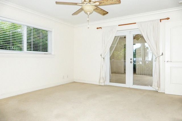 spare room with light carpet, crown molding, french doors, and ceiling fan