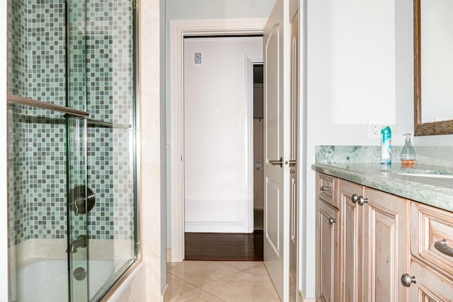 bathroom with tile patterned flooring, vanity, and enclosed tub / shower combo