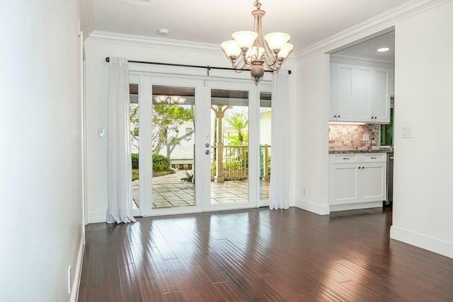 doorway featuring ornamental molding, dark hardwood / wood-style floors, a chandelier, and french doors