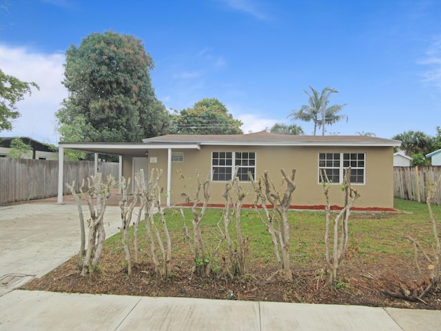 view of front of house with a carport and a front yard