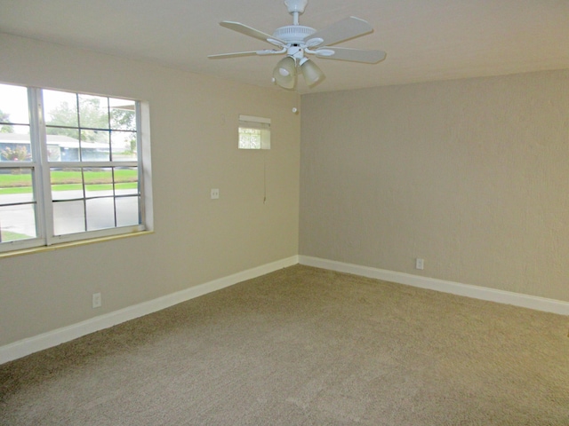 spare room featuring ceiling fan, plenty of natural light, and carpet