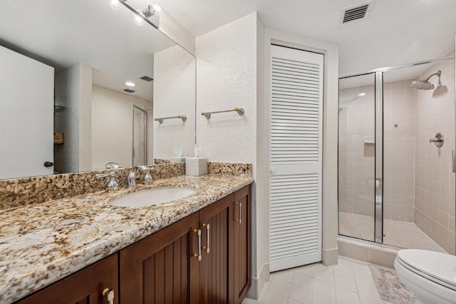 bathroom with vanity, toilet, an enclosed shower, and tile patterned flooring