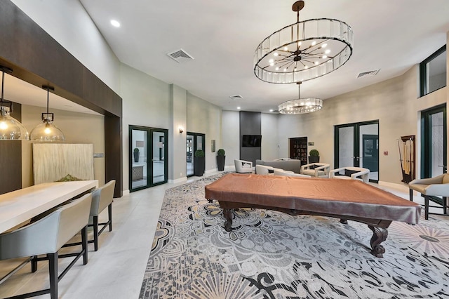 recreation room with an inviting chandelier, billiards, french doors, and a high ceiling