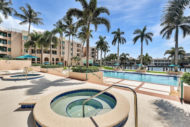 view of swimming pool with a hot tub and a patio area