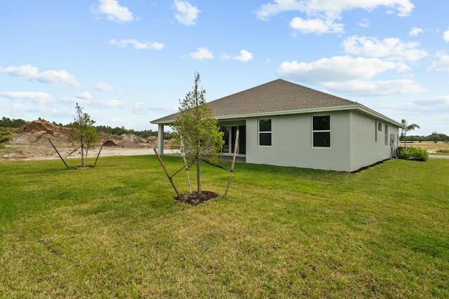 back of property featuring a lawn