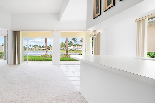 corridor with light colored carpet and a water view