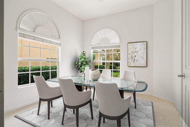 dining area with baseboards and light colored carpet