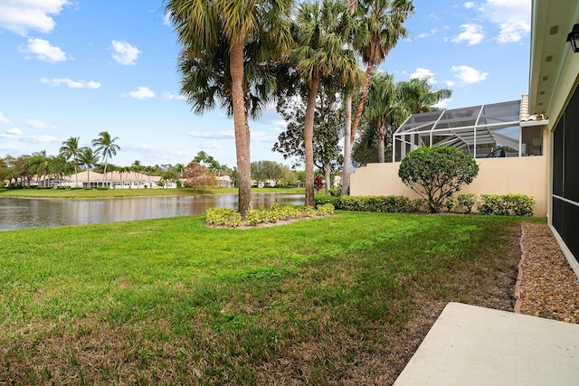 view of yard featuring glass enclosure and a water view