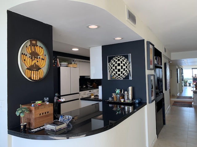 kitchen with white cabinetry, tile patterned floors, and kitchen peninsula