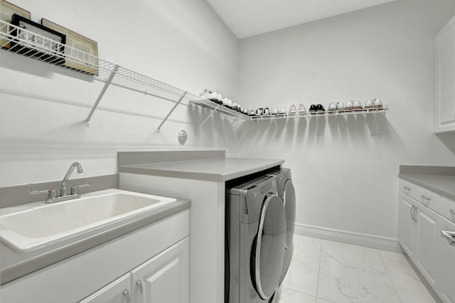 washroom with cabinets, sink, and washer and clothes dryer