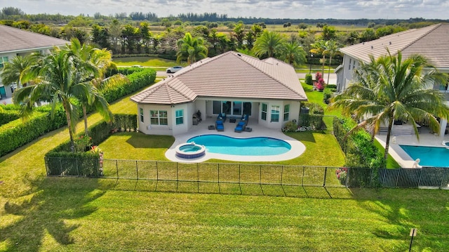 view of swimming pool featuring a patio area, a lawn, and an in ground hot tub