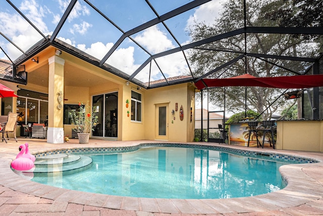 outdoor pool featuring a ceiling fan, a patio area, and glass enclosure