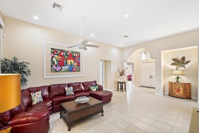 living room featuring light tile patterned floors, a ceiling fan, baseboards, recessed lighting, and arched walkways