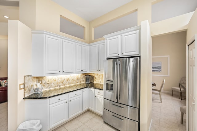 kitchen with white cabinetry, light tile patterned floors, stainless steel fridge, and backsplash