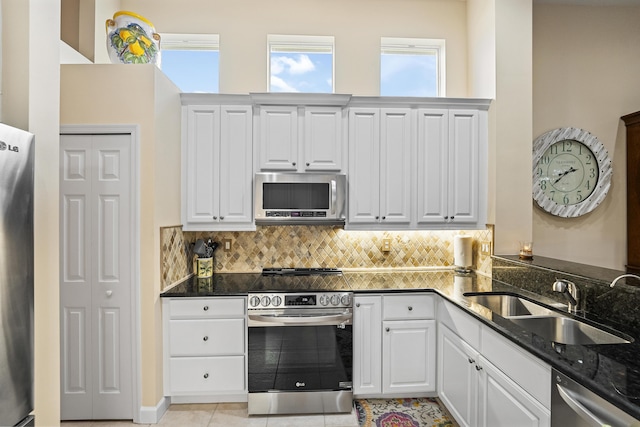 kitchen featuring a sink, white cabinets, backsplash, and stainless steel appliances