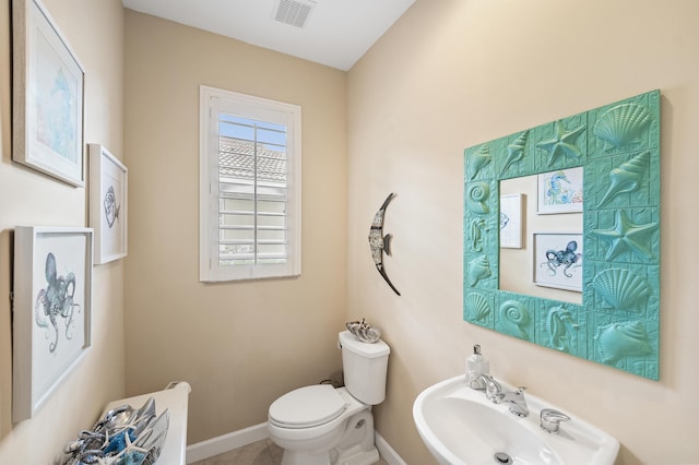 bathroom with a sink, visible vents, baseboards, and toilet