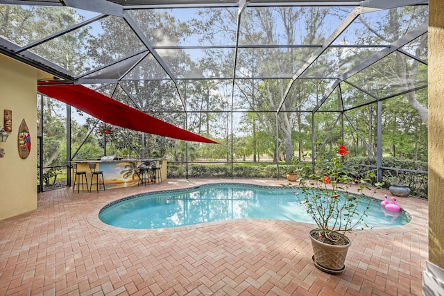 pool with outdoor dry bar, a patio area, and a lanai