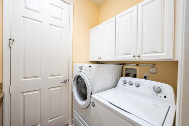 washroom with washing machine and dryer and cabinet space