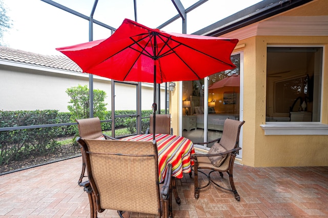 view of patio / terrace with outdoor dining space and a lanai