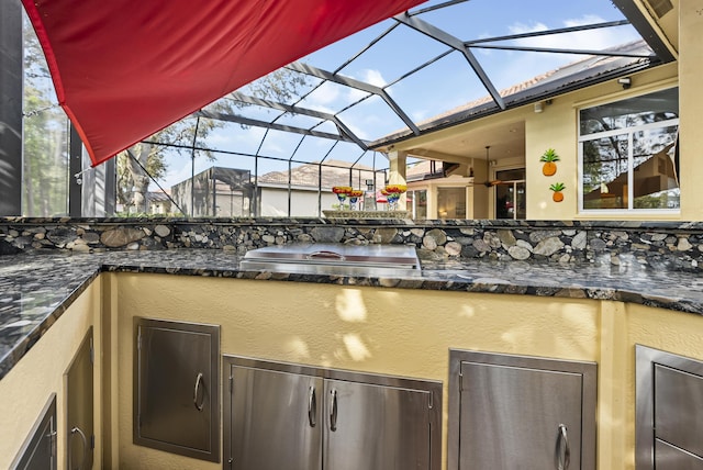 view of patio with an outdoor kitchen and glass enclosure