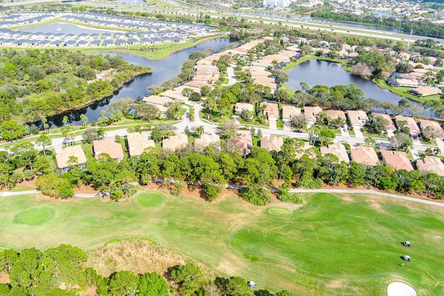 drone / aerial view with view of golf course, a water view, and a residential view