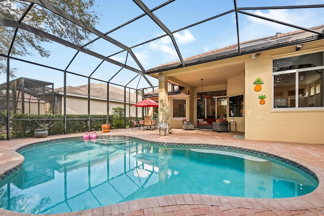 pool with an outdoor living space, glass enclosure, and a patio