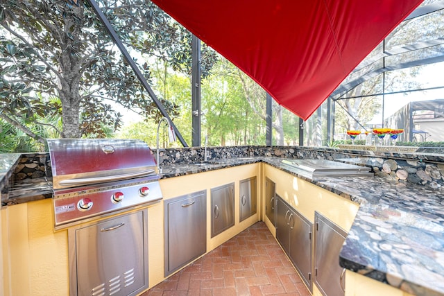 view of patio featuring glass enclosure, area for grilling, and grilling area