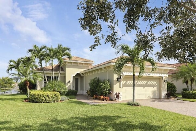 mediterranean / spanish-style home featuring a garage and a front yard