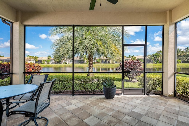 sunroom with a water view and ceiling fan