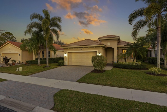 6301 SE Turn Leaf Trl, Hobe Sound, FL 33455 - mediterranean / spanish-style home featuring a front lawn, decorative driveway, an attached garage, and stucco siding