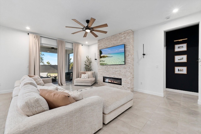 living room featuring a stone fireplace, ceiling fan, and light tile patterned flooring