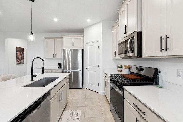 kitchen featuring white cabinetry, sink, decorative light fixtures, and stainless steel appliances