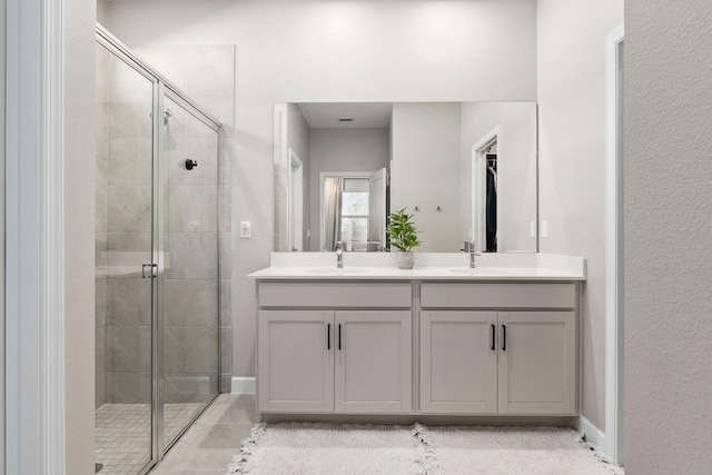 bathroom featuring a shower with door and vanity