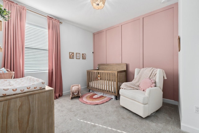 bedroom featuring light carpet and a nursery area