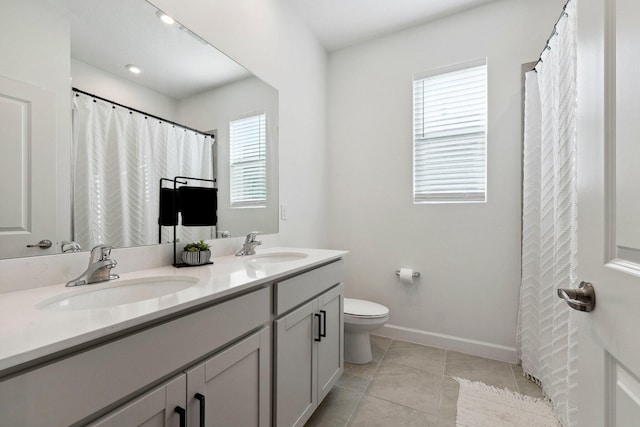 bathroom with tile patterned flooring, vanity, and toilet