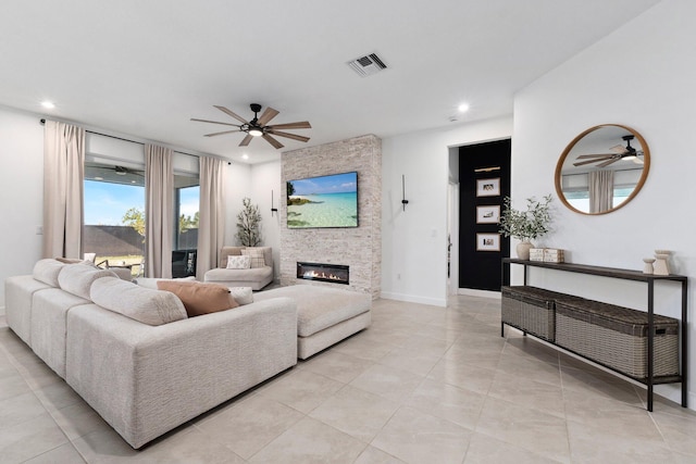 tiled living room featuring ceiling fan and a fireplace