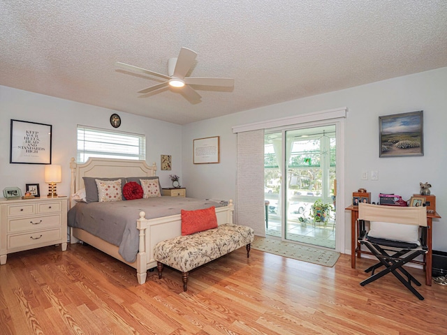 bedroom featuring light hardwood / wood-style flooring, ceiling fan, access to outside, and a textured ceiling