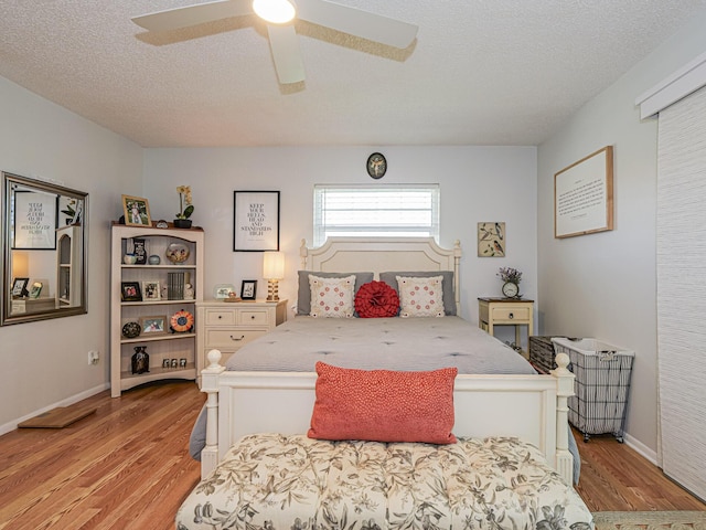 bedroom featuring ceiling fan, a textured ceiling, and light hardwood / wood-style floors