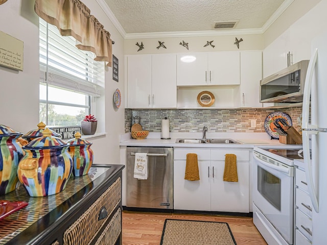 kitchen featuring appliances with stainless steel finishes, sink, white cabinets, and light hardwood / wood-style floors