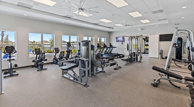 exercise room with a healthy amount of sunlight, a drop ceiling, and ceiling fan