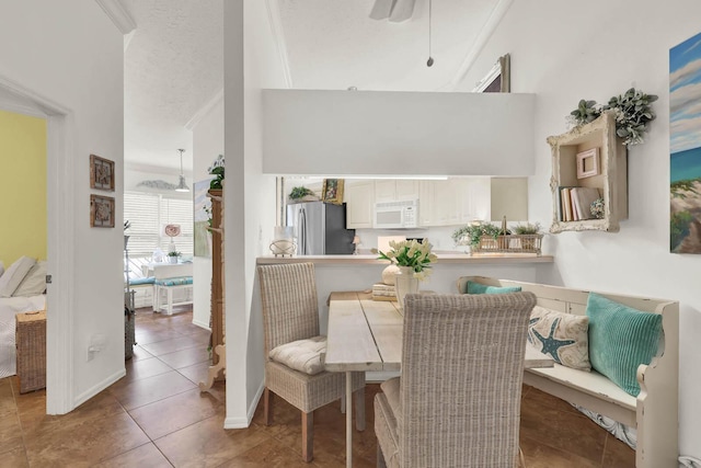 tiled dining room with a textured ceiling and ceiling fan