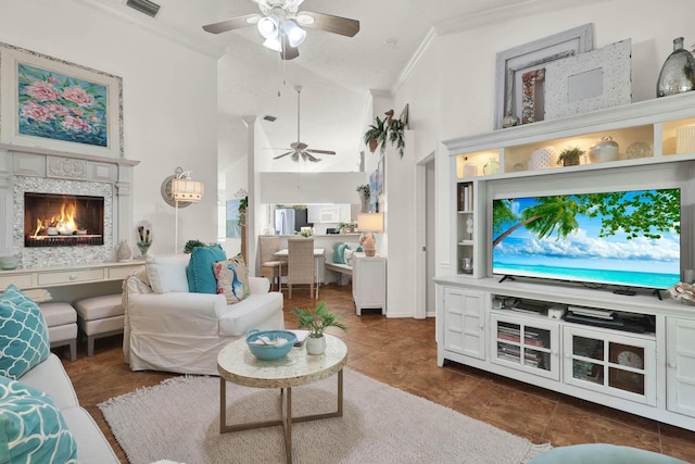 tiled living room featuring ceiling fan, ornamental molding, and high vaulted ceiling