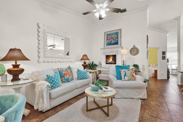 tiled living room with ornamental molding and ceiling fan