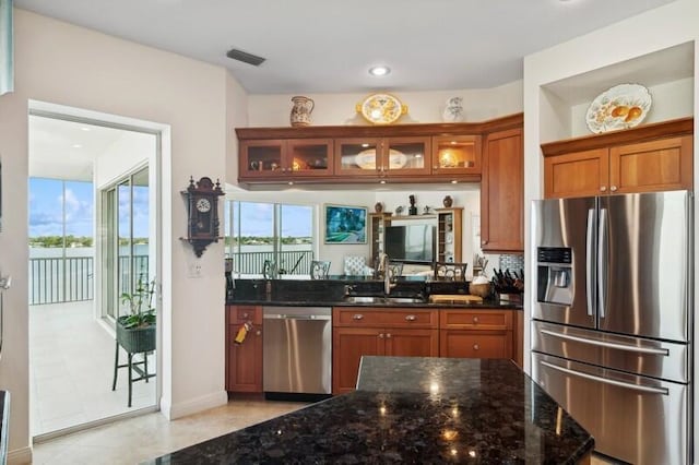 kitchen with dark stone countertops, sink, and appliances with stainless steel finishes