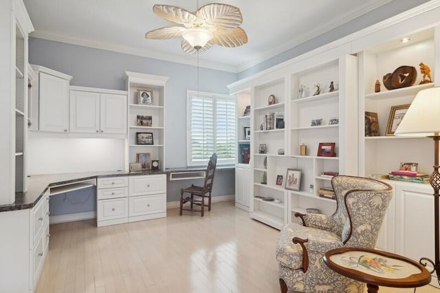 home office with ceiling fan, ornamental molding, built in desk, and light wood-type flooring