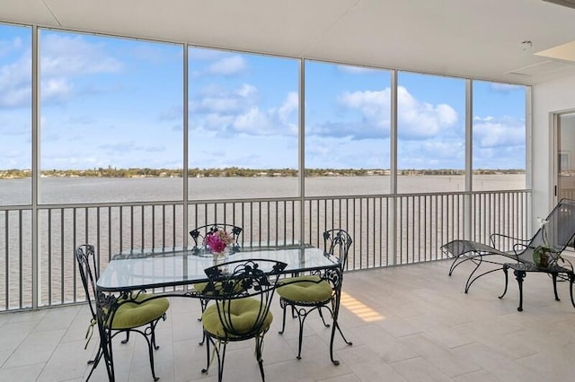 sunroom featuring a water view