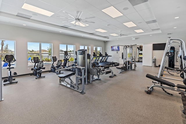 exercise room with a drop ceiling, plenty of natural light, and ceiling fan