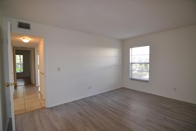 spare room featuring hardwood / wood-style flooring and a healthy amount of sunlight