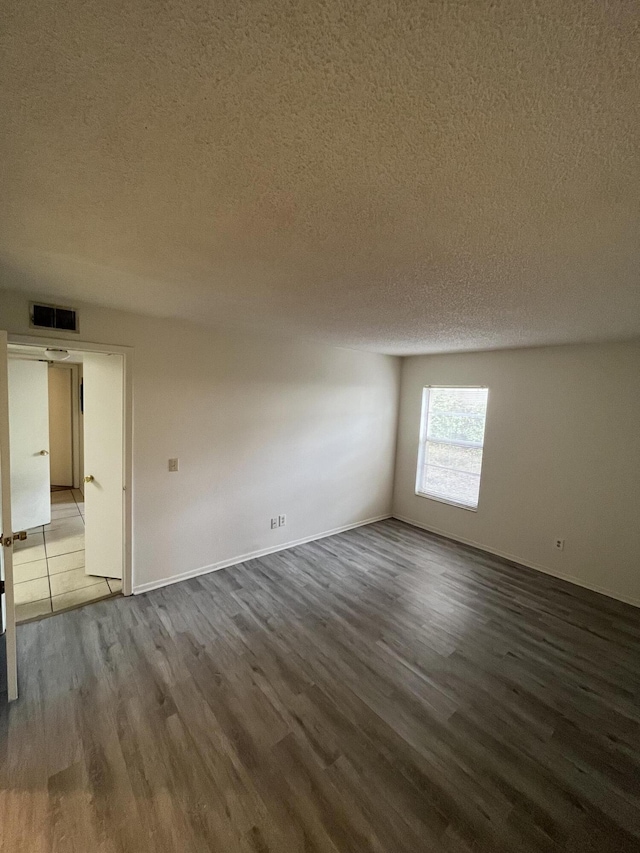 spare room with wood-type flooring and a textured ceiling