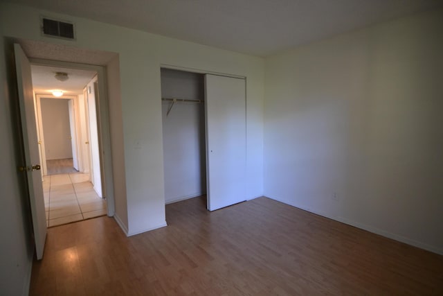 unfurnished bedroom featuring a closet and hardwood / wood-style flooring